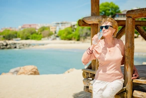 Life Assure Senior Woman Sitting In Chair And Laughing With Caregiver Nurse Blog